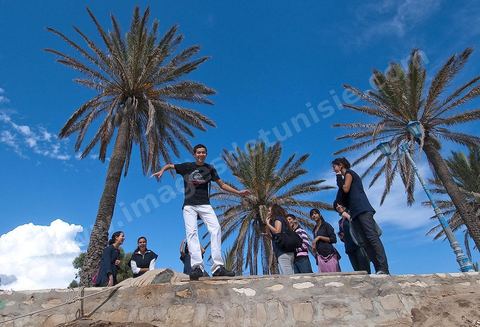 Groupe de jeunes adolescents sur la plage le long des remparts de la medina de Hammamet