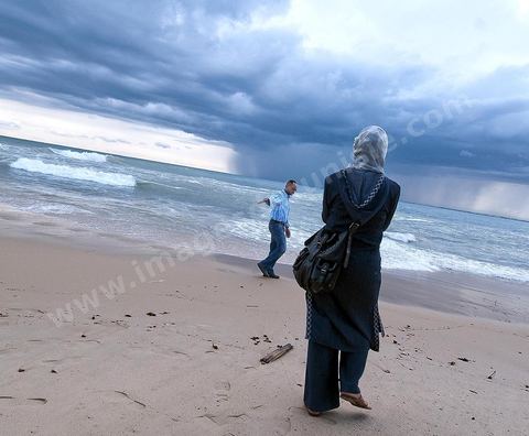Couple de jeune mariée avec femme voilée sur la plage le long des remparts de la medina de Hammamet