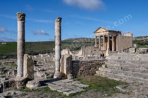 Capitole de Dougga et son majestueux temple. Le site de Dougga, classé au patrimoine mondial de l'UNESCO, Situé sur un éperon dominant la riche vallée de la Mejerdah, le site s'étend sur plusieurs dizaines d'hectares et couvre plusieurs ères historiques. L’excellent état de conservation de la plupart des monuments qui le composent dont certains, tels le capitole ou le théâtre, ont été « remis sur pied » au cours d’une campagne menée au lendemain de la première guerre mondiale par des prisonniers de guerre.