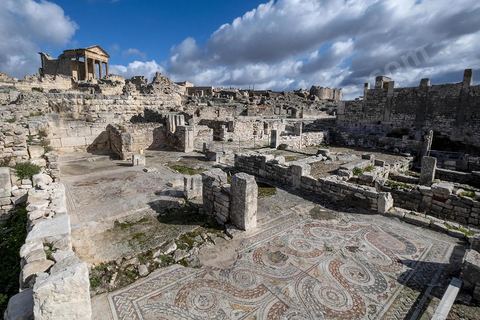 Capitole de Dougga et son majestueux temple et au premier plan villas. Le site de Dougga, classé au patrimoine mondial de l'UNESCO, Situé sur un éperon dominant la riche vallée de la Mejerdah, le site s'étend sur plusieurs dizaines d'hectares et couvre plusieurs ères historiques. L’excellent état de conservation de la plupart des monuments qui le composent dont certains, tels le capitole ou le théâtre, ont été « remis sur pied » au cours d’une campagne menée au lendemain de la première guerre mondiale par des prisonniers de guerre.