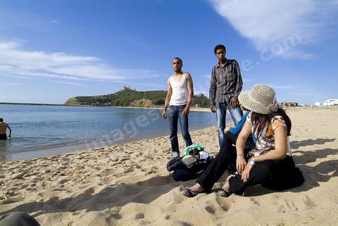 Adolescents sur la plage de Tabarka avec au fond la colline du fort génois