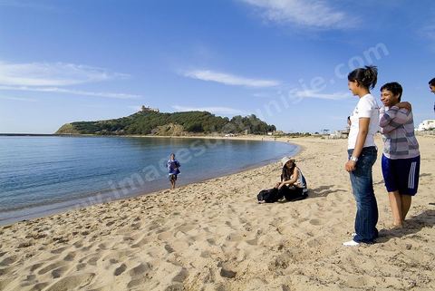 Adolescents sur la plage de Tabarka avec au fond la colline du fort génois