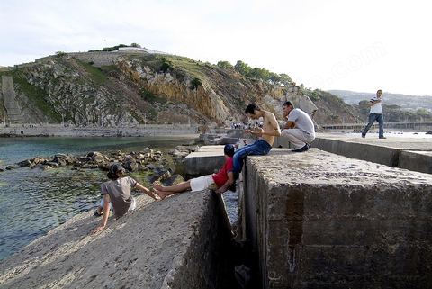 Jeuns adolescent flânant, se baignant et plongeant sur la digue au pied des aiguilles de Tabarka