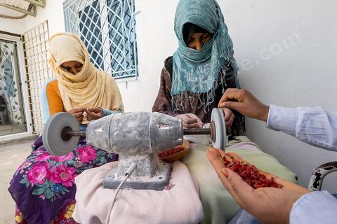 les ouvrières taillent et polissent le corail dans l'atelier de Mokthar, installé dans la cour de sa maison à Tabarka