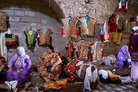 Mahdia, marché aux costumes traditionnels par les femmes de la région. Ce marché traditionnel perdure depuis des années et a lieu sous la Skifa El Kahla de Mahdia. Les femmes vendent ici les costumes traditionnels féminins pour les mariages. Costumes en soie, fil d'or et d'argent tissées par les femmes chez elles.