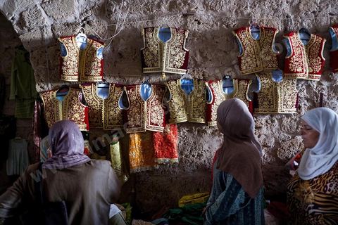 Mahdia, marché aux costumes traditionnels par les femmes de la région. Ce marché traditionnel perdure depuis des années et a lieu sous la Skifa El Kahla de Mahdia. Les femmes vendent ici les costumes traditionnels féminins pour les mariages. Costumes en soie, fil d'or et d'argent tissées par les femmes chez elles.