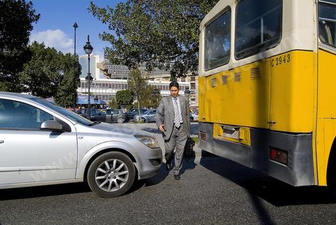 A yellow bus, a car, and a pedestrian on Habib Bourguiba Avenue in Tunis. Traffic and traffic jams in Tunis