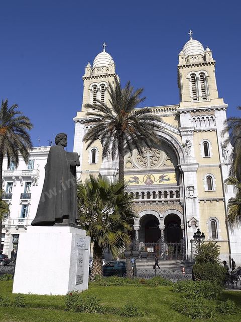 The facade of Tunis Cathedral on Place de France, with the statue of Ibn Khaldoun in the foreground