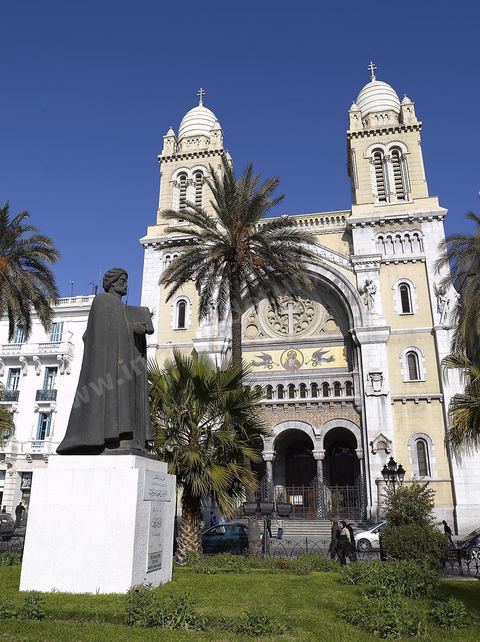 The facade of Tunis Cathedral on Place de France, with the statue of Ibn Khaldoun in the foreground