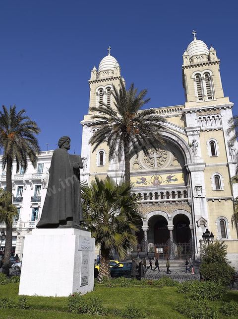 The facade of Tunis Cathedral on Place de France, with the statue of Ibn Khaldoun in the foreground
