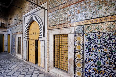 Patio à jardin du Dar Othman palais de la medina de Tunis - porte jaune ancienne et mur de céramiques