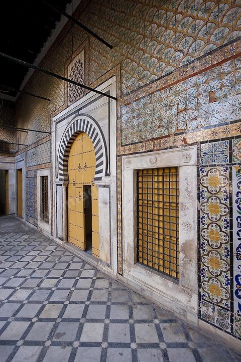 Patio à jardin du Dar Othman palais de la medina de Tunis - porte jaune ancienne et mur de céramiques