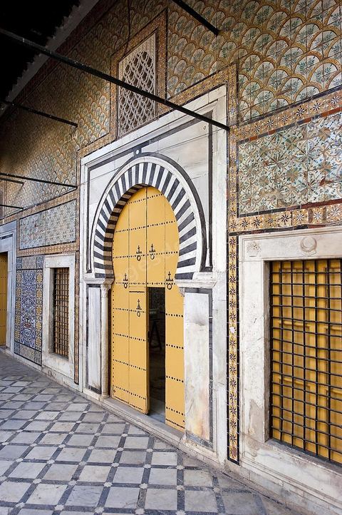 Patio à jardin du Dar Othman palais de la medina de Tunis - porte jaune ancienne et mur de céramiques