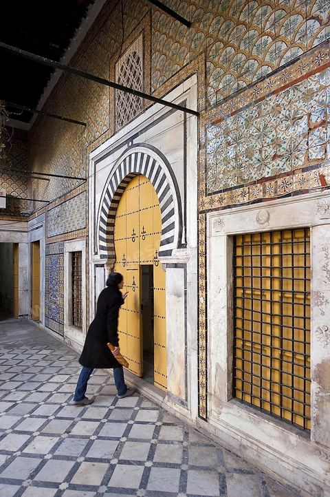 Patio à jardin du Dar Othman palais de la medina de Tunis - porte jaune ancienne et mur de céramiques