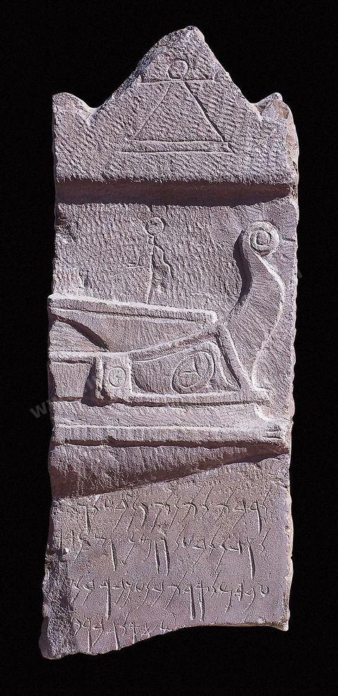 A limestone stele whose pediment is adorned with the so-called sign of Tanit and whose first register depicts a ship similar to the admiral’s galleys on Barcid coins. With its shield on the hull and its trident-shaped stem, it is likely a warship. The second register, which is partially destroyed, contains an invocation to Tanit and Baal Hammon; provenance: Tophet of Carthage; late 3rd century BCE; Punic section; Bardo Museum