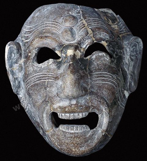 A grotesque, grimacing terracotta mask. This type of mask, inherited from the Phoenicians, was placed in tombs to protect the dead from demons (H. 18 cm, W. 16 cm, Dermech Necropolis, Carthage, late 8th century–early 7th century, Carthage Museum).