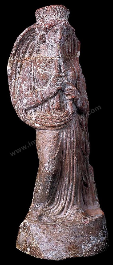 Figurine en terre cuite représentant une femme jouant de la double flûte. Elle porte une tunique longue te un manteau formant voile autour de sa tête, un diadème à palmette et des bijoux (H. 23 cm, nécropole de Borj Jedid, Carthage, IVème siècle avant JC, musée de Carthage).