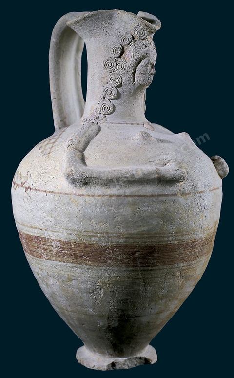 Oenochoé anthropomorphe à bec trilobé évoquant une femme enceinte. Appliquée au col de la cruche, la tête, finement dessinée, possède une abondante chevelure ondulée qui encadre le visage aux traits réguliers. Le cou est orné d’un collier dont les perles sont rehaussées de touches de peinture. Les seins sont figurés sur la partie supérieure de la panse. Les bras ramenés devant portent des bracelets de couleur sombre. On perçoit ici l’influence de vieilles traditions mésopotamiennes liées au thème de la déesse mère (H. 31‑cm, ø‑19‑cm, Henchir Beni Nafaa, près de Bizerte, IIIe‑siècle av.‑J.-C.,) section punique - musée du Bardo