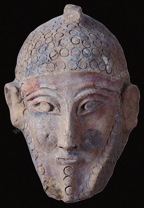 Terracotta mask of a man. These solid, engraved masks appear designed to attract the goodwill and protection of benevolent powers (H. 20 cm, Carthage, early 5th century B.C., Bardo Museum). Punic section—Bardo Museum
