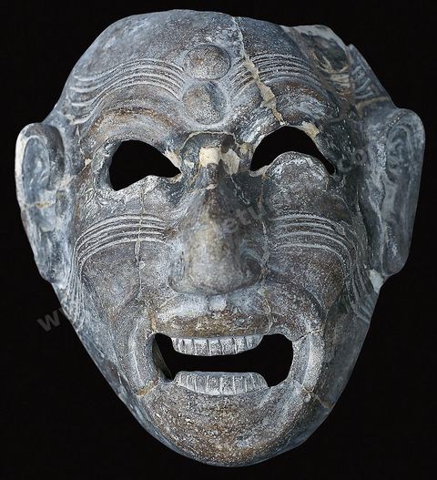 A grotesque, grimacing terracotta mask. This type of mask, inherited from Phoenicia, was placed in tombs to protect the dead from demons (H. 18 cm, W. 16 cm, Dermech Necropolis, Carthage, late 8th or early 7th century, Carthage Museum). Punic Section
