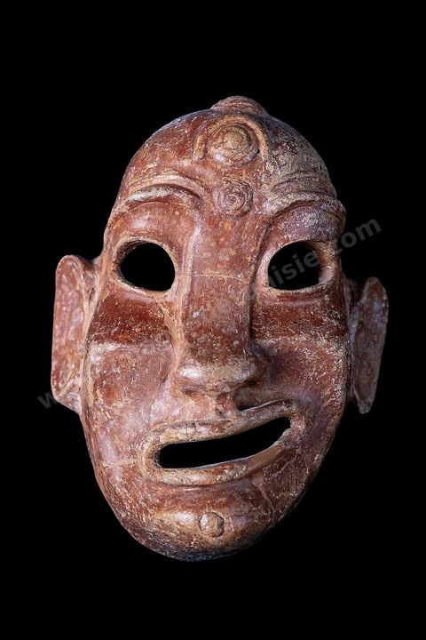Masque en terre cuite négroïde au visage déformé par un rictus. Le front porte en relief le croissant lunaire et un disque, les oreilles sont ornées d’anneaux en terre cuite (H. 20‑cm, nécropole de Douimès, Carthage, fin du VIIe-début du VIe‑siècle av.‑J.-C., musée du Bardo). Section punique - musée du Bardo