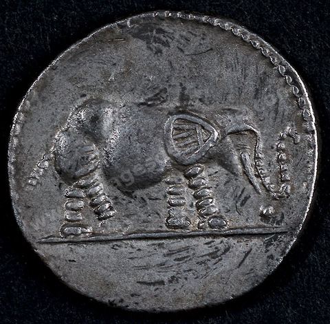Monnaie d’argent représentant à l’avers le buste de Juba II, roi de Maurétanie (25‑av. J.-C. 24 ap. J.-C.), dont la tête est‑couverte d’une dépouille de lion. Un‑éléphant figure au revers. Cette‑monnaie porte des motifs africains traditionnels tel l’éléphant, et l’évocation d’Héraclès (dépouille de lion) rappelle la légende qui fait remonter la famille royale à Héraclès Melqart pour fonder et légitimer un culte royal à la manière hellénistique. Section punique - musée du Bardo