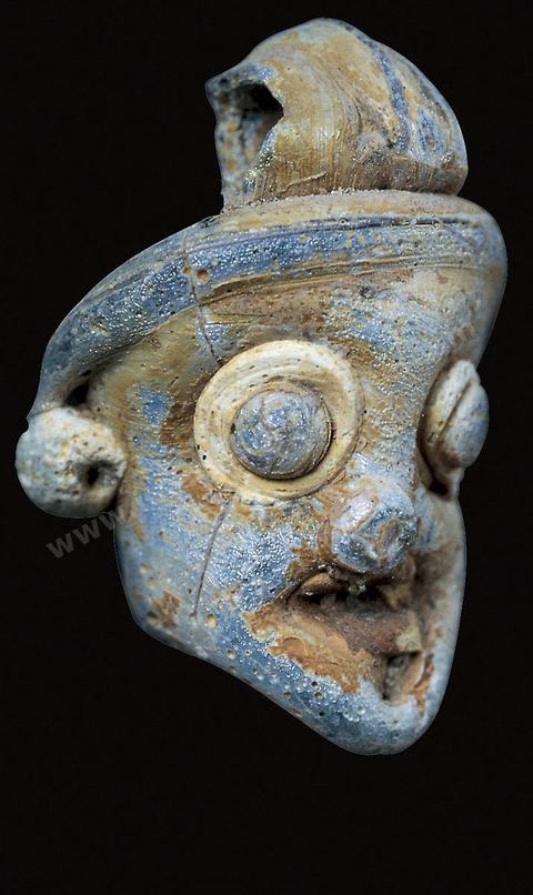 Masques-pendentifs en pâte de verre de différentes couleurs (gris et bleu, blanc et noir, bleu et jaune). Fortement typés, ils ont des yeux exorbités dont l’iris est dilaté et des cheveux et une barbe souvent calamistrés en forme de tortillons. Une bélière permet de les enfiler dans des colliers ou de les porter comme pendentifs. Leur grande vogue se situe aux IVe‑et‑IIIe‑siècles (H.4‑à 6‑cm, nécropoles de‑Carthage, IVe-IIIe siècle av. J.-C., musées du Bardo). Section punique - musée du Bardo