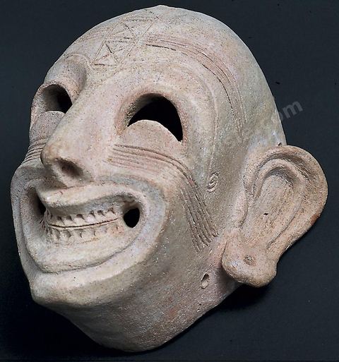 Masque grimaçant en terre cuite : le visage est fortement plissé et ridé, surmonté d’un bandeau crânien. Il semble d’inspiration mésopotamienne (démon Humbaba) (H. 16‑cm, nécropole de Dermech, Carthage, fin du VIe‑siècle av.‑J.-C., musée du Bardo). Section punique - musée du Bardo