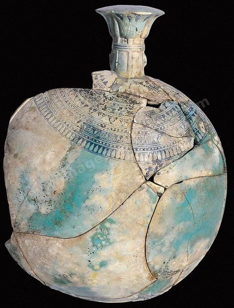 Fiole égyptisante en faïence émaillée, portant un décor de fleurs et de lotus autour du col. Des rosaces, perles, feuilles lancéolées et boutons de lotus ornent la panse. Le nom du pharaon Ahmasisineiter est inscrit en hiéroglyphes près du col. Datant du VIe‑siècle av. J.-C., elle a été trouvée dans une tombe du IVe siècle av. J.-C. à Carthage (H. 21‑cm, ø16‑cm, musée du Bardo). Section punique - musée du Bardo
